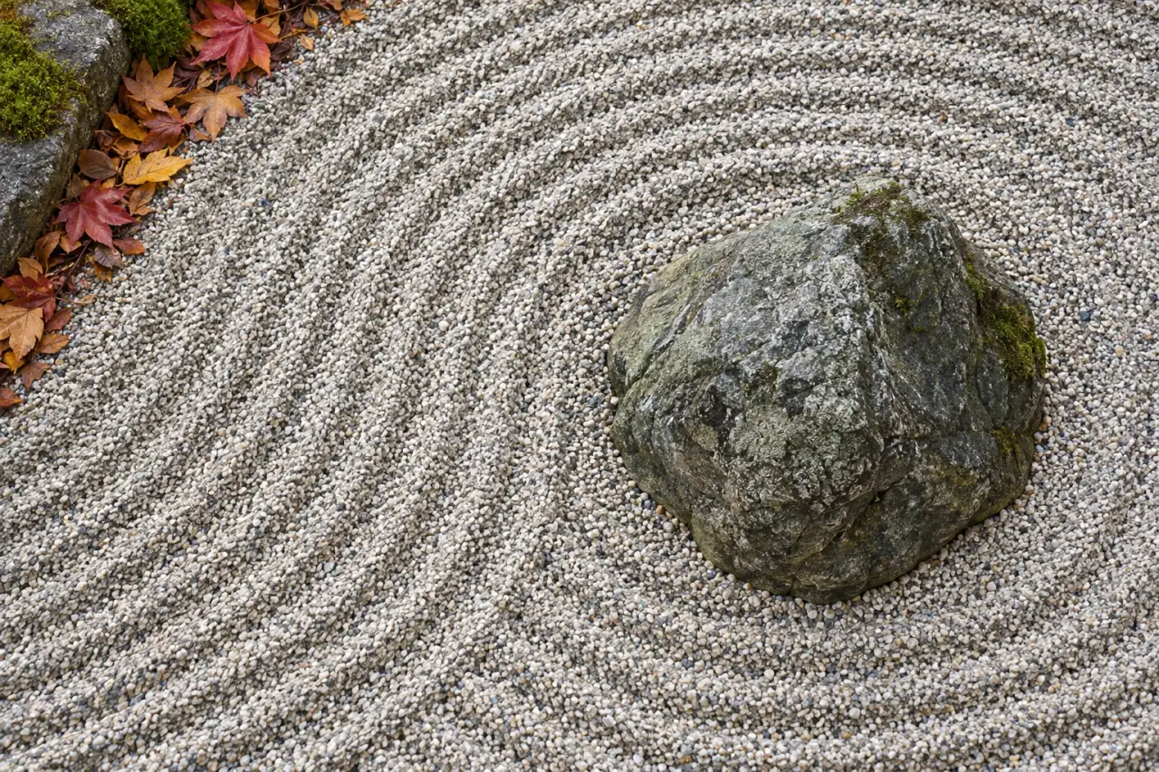 Gepflegte Kiesfläche mit erneuerten Linien um einen Naturstein
